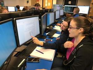 Students in Computer Lab pointing to a computer monitor