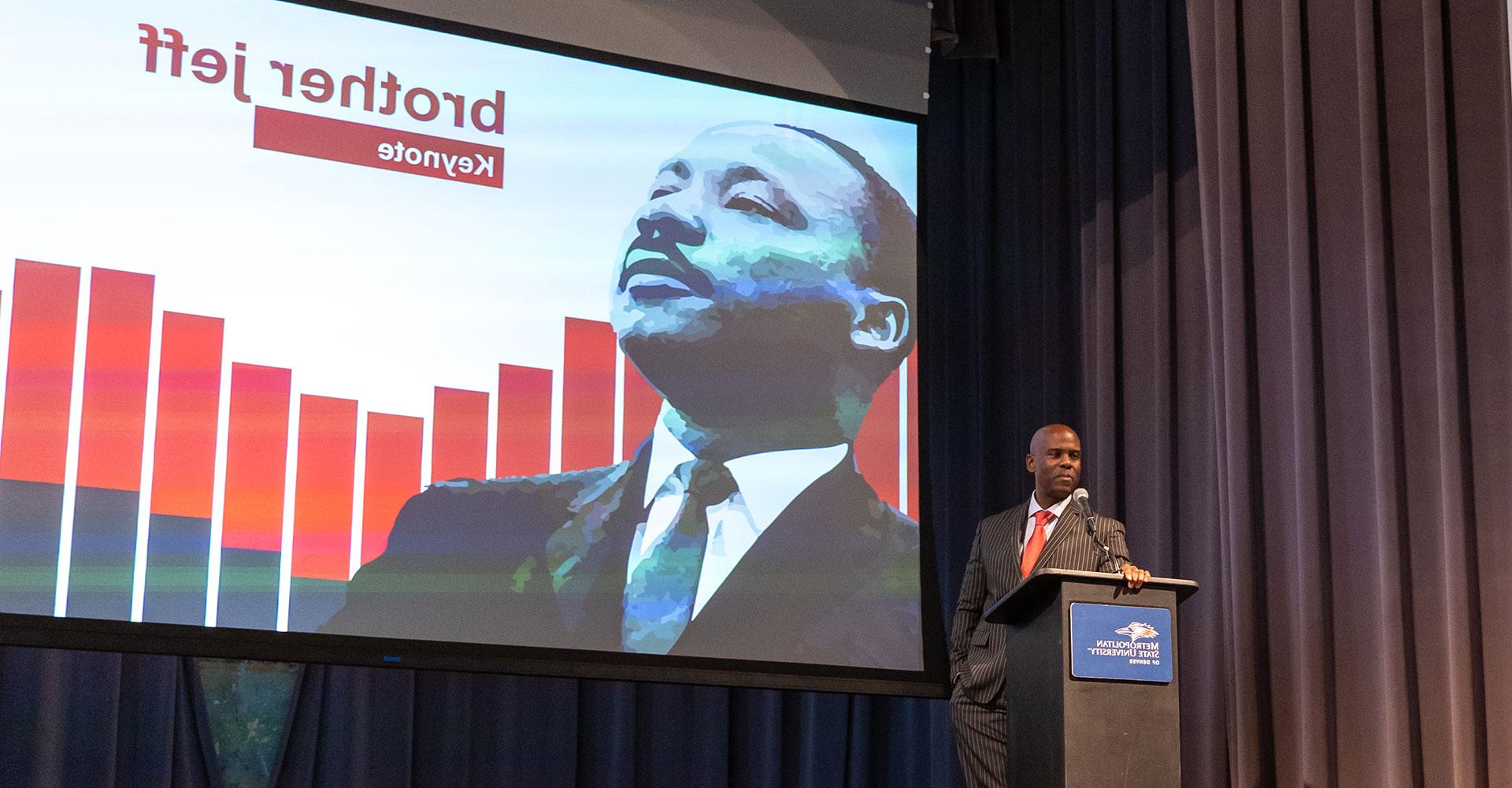 Jeff Fard, aka brother jeff, at an MSU Denver podium with a photo of Dr. King on a slide behind him