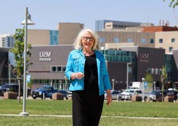 Barb Grogan standing near the Tivoli with the SpringHill Suites in the background